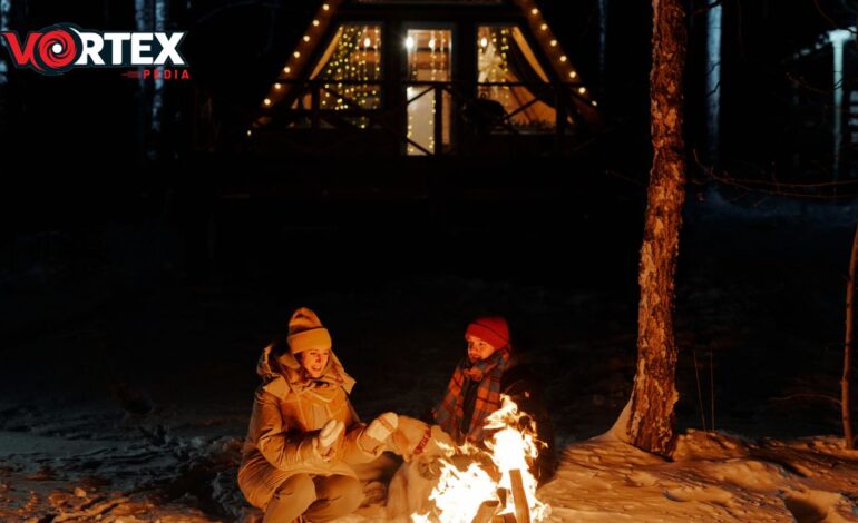 This image showing a couple sitting outside Infront of fire in cold.