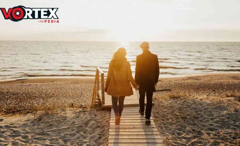 This image showing that a couple is walking in the evening near ocean.