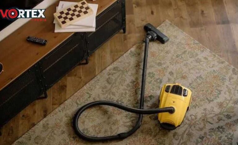 THis image showing a vacume cleaner in yellow colour is laying on brown carpet,