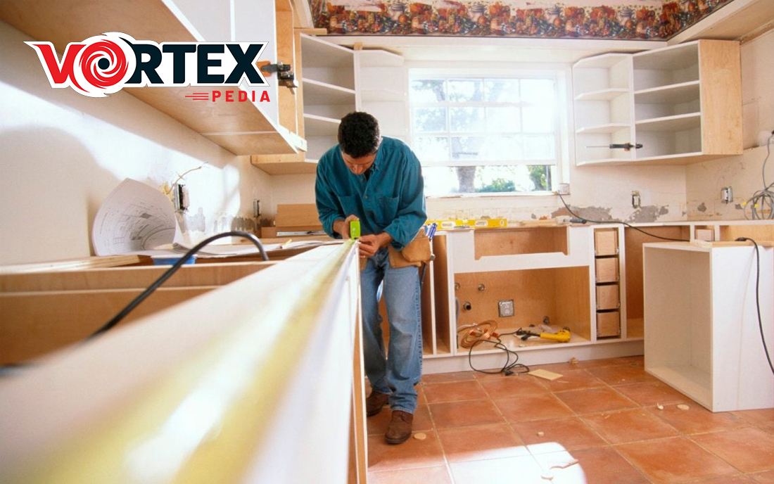 A man is remodeling the kitchen with so focus.