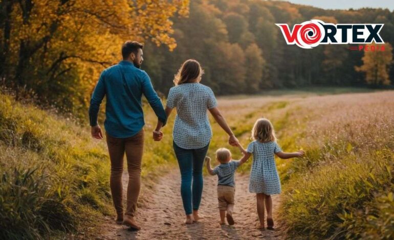 A family walking hand-in-hand in a scenic field during autumn.